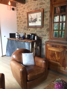 un fauteuil en cuir brun dans une chambre avec une table dans l'établissement Le Pas Saint Joseph, à Saint-Malo