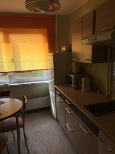 una pequeña cocina con mesa, mesa y ventana en sunny apartment, en Ventspils