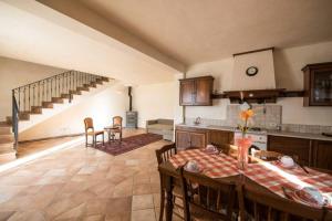 cocina y comedor con mesa y sillas en La Casa Vacanza con vista panoramica sui vigneti, en Rotella