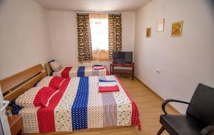 a bedroom with two beds with red white and blue blankets at Old House in Vama Veche