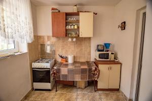 a small kitchen with a table and a microwave at Old House in Vama Veche