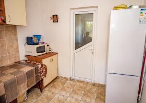 a kitchen with a white refrigerator and a microwave at Old House in Vama Veche