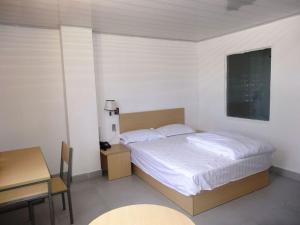 a bedroom with a bed and a table and a desk at Airlines Business Hotel in Port Vila