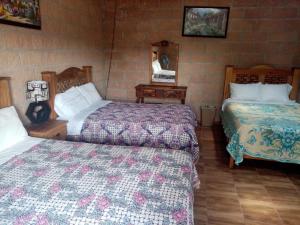 a hotel room with two beds and two tables at Hotel La Cabaña in San Miguel de Allende