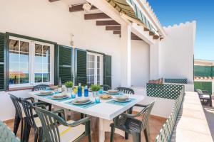 a dining room with a white table and chairs at Villa Paloma by Villa Plus in Cala'n Porter