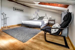 1 dormitorio con 1 cama, 1 silla y 1 alfombra en Hotel La Fonda De La Estación, en La Puebla de Valverde