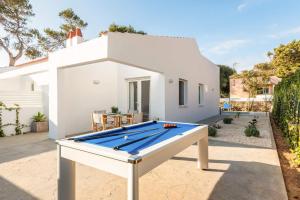 a pool table in front of a white house at Villa Pins Ciutadella by Villa Plus in Cala Blanca