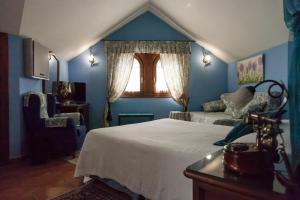 a blue bedroom with a bed and a window at Posada Carpe Diem in Liérganes