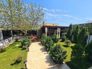 a backyard with trees and a patio with a house at Vila Ale in Mamaia Sat/Năvodari