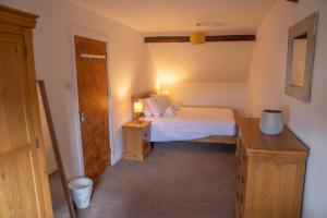a bedroom with a bed and a desk with a lamp at Low Haven in Keswick
