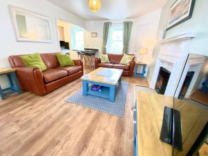 a living room with a couch and a fireplace at Cosy, Modern 2 Bedroom Apartment in the Centre of Inveraray in Inveraray