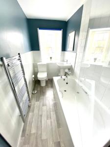 y baño con lavabo, bañera y aseo. en Cosy, Modern 2 Bedroom Apartment in the Centre of Inveraray, en Inveraray