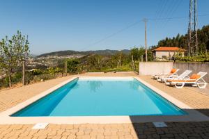 - une piscine avec 2 chaises et une maison dans l'établissement Casa da Cabine, à Castelo de Paiva