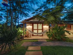 a villa with a hammock in the garden at night at Aldeia Patacho in Pôrto de Pedras