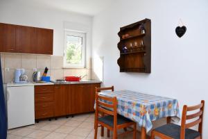 cocina con mesa, mesa y sillas en apartmani Novotny plavi, en Banjol