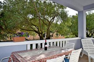 una mesa con una botella de vino en el balcón en apartmani Novotny plavi, en Banjol