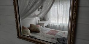 a mirror in a room with a bed and a window at Villa Harmónia in Gyula