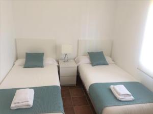 Duas camas individuais num quarto com um candeeiro. em Casa Oliva Playa Bolonia em Tarifa