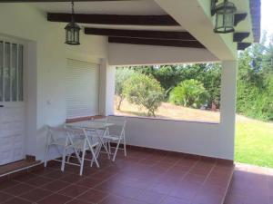 un patio con sillas, una mesa y una ventana en Casa Oliva Playa Bolonia en Tarifa