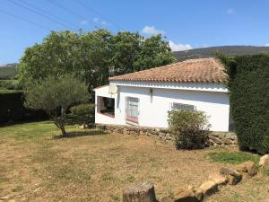 une maison blanche avec un mur en pierre dans une cour dans l'établissement Casa Oliva Playa Bolonia, à Tarifa