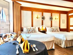 a hotel room with two beds and a table with a wine glass at Le Chateau de Pierre in Quebec City