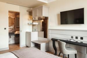 a small kitchen with a desk and a television in a room at Hotel Pjazza Merkanti - Boutique Living in Valletta