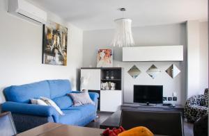 a living room with a blue couch and a tv at Apartments Alba in El Médano