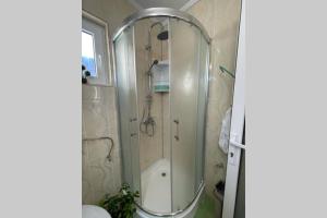 baño con ducha y puerta de cristal en Apartament Cristina - Băile 1 Mai, Felix, Bihor, reducere jumătate intrare Aquapark President, en Baile 1 Mai
