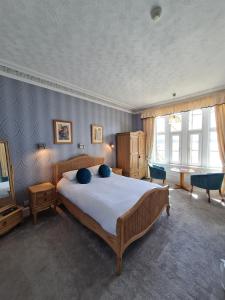 une chambre avec un grand lit et une télévision dans l'établissement Corriemar House, à Oban