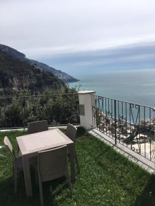 a table and chairs on a balcony with a view of the ocean at Casa Roberta in Positano