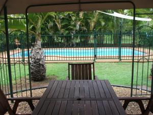 a wooden table and chairs in front of a swimming pool at Bungadoo Country Cottage in Bullyard