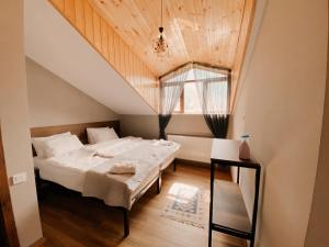 a bedroom with a large bed and a window at Villa Kazbegi in Stepantsminda