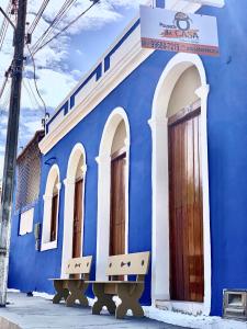 a blue building with a bench in front of it at Pousada Ô de Casa in Piranhas