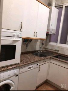 cocina blanca con fregadero y microondas en Arta, en Madrid