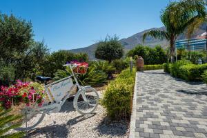 a bike parked in a garden with flowers at BLU House Wellness & SPA in Castellammare del Golfo