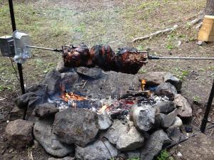 a grill with a bunch of food cooking over a fire at Silvern Lake Trail Bed and Breakfast in Smithers