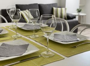 une table avec quatre verres à vin en haut dans l'établissement Andrea Apartmanok, à Hajdúszoboszló