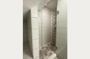 a shower with glass doors in a bathroom at Andrea Apartmanok in Hajdúszoboszló +4 photos