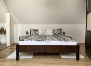 a bed in a white room with a bedvisor at Andrea Apartmanok in Hajdúszoboszló