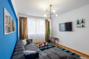 Modern & Stylish Apartment Excellent Location Superhost في كونستانتا: غرفة معيشة مع أريكة وتلفزيون