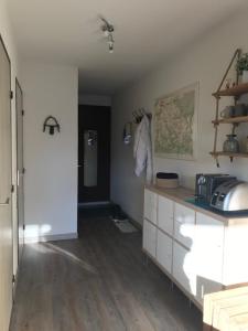 a room with a kitchen with white cabinets and a counter at Appartement Hauteur Barcelonnette Vue Exceptionnelle in Barcelonnette