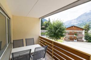 d'un balcon avec des tables et des chaises et une grande fenêtre. dans l'établissement Cristal 28, à Loèche-les-Bains