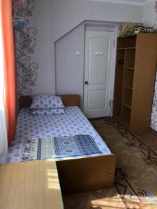 a small bedroom with a bed and a door at Gostevoy Dom Magadan in Anapa