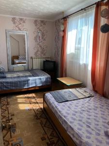 a hotel room with two beds and a mirror at Gostevoy Dom Magadan in Anapa