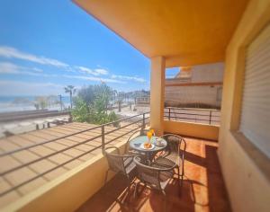 a balcony with a table and chairs and the beach at Primera línea Morro de Goss in Oropesa del Mar
