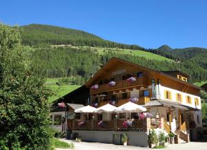 a building with white umbrellas in front of it at Hotel/ App. Garber in San Giacomo