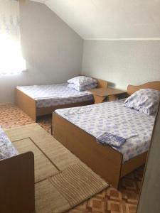 a room with two beds and two tables in it at Gostevoy Dom Magadan in Anapa