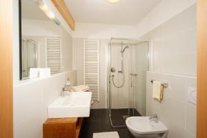 a white bathroom with a sink and a shower at Hotel/ App. Garber in San Giacomo