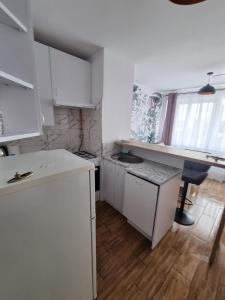 a kitchen with white cabinets and a table and a desk at Kawalerka blisko jeziora in Olecko