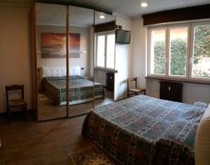 um quarto com 2 camas e um espelho em azalea apartments domo2 em Baveno